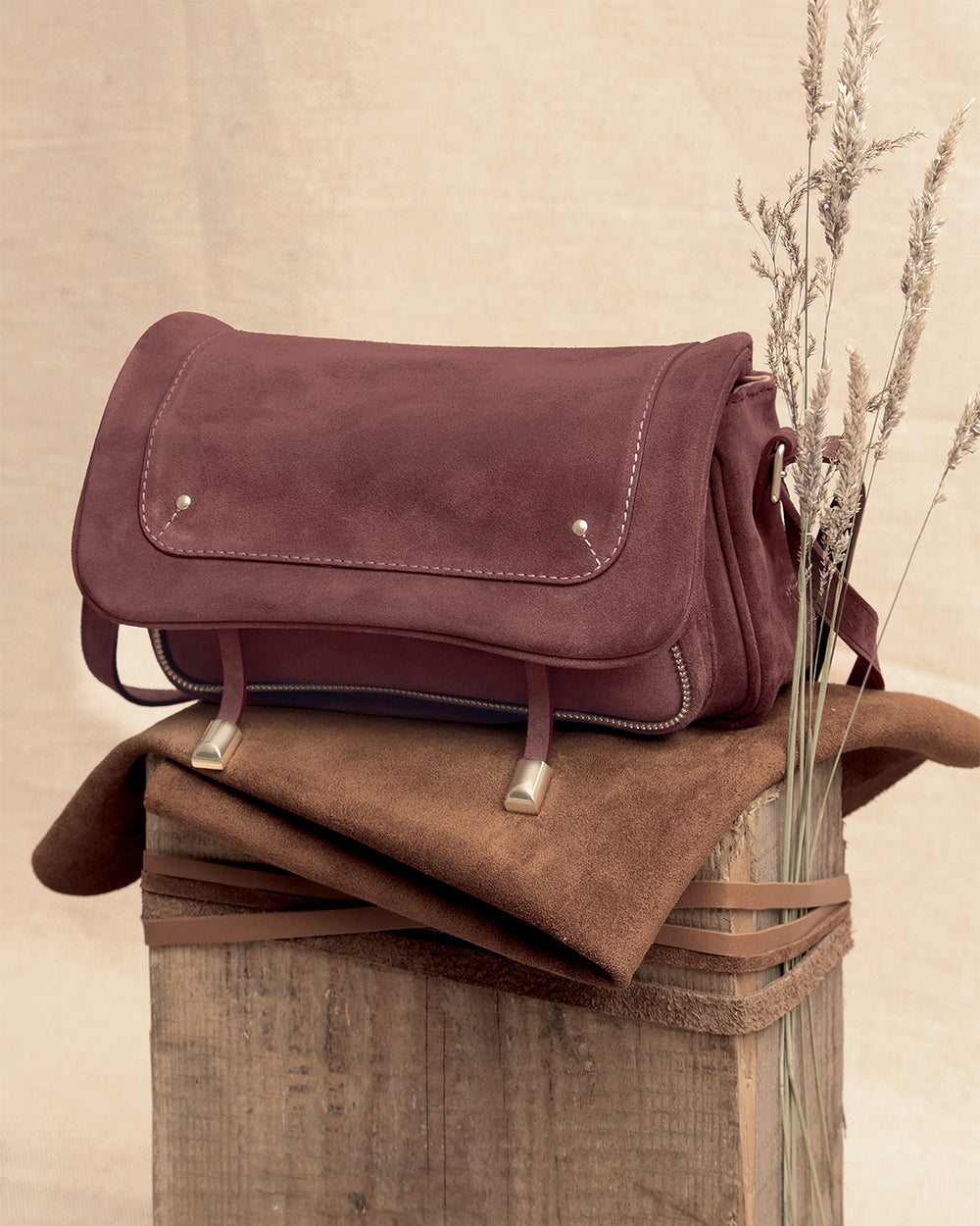 Le sac Lou Renouard en cuir veau velours acajou et ses accessoires dorés, vu de quart en ambiance.