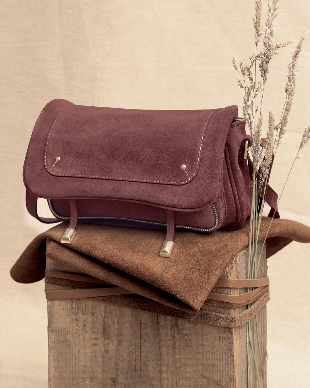 Le sac Lou Renouard en cuir veau velours acajou et ses accessoires dorés, vu de quart en ambiance.