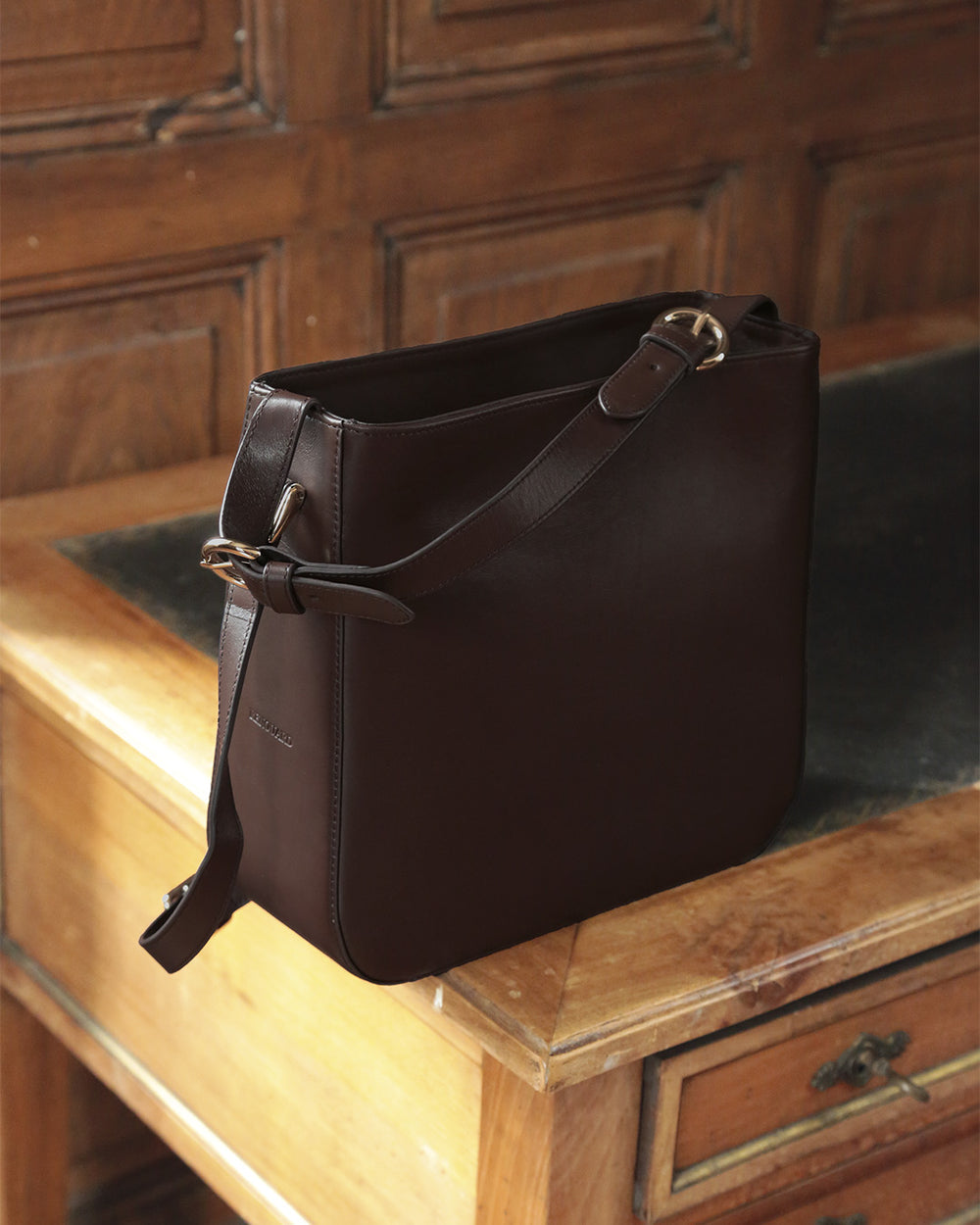 Notre sac Marlow Renouard en cuir lisse ébène, vu de quart en ambiance.