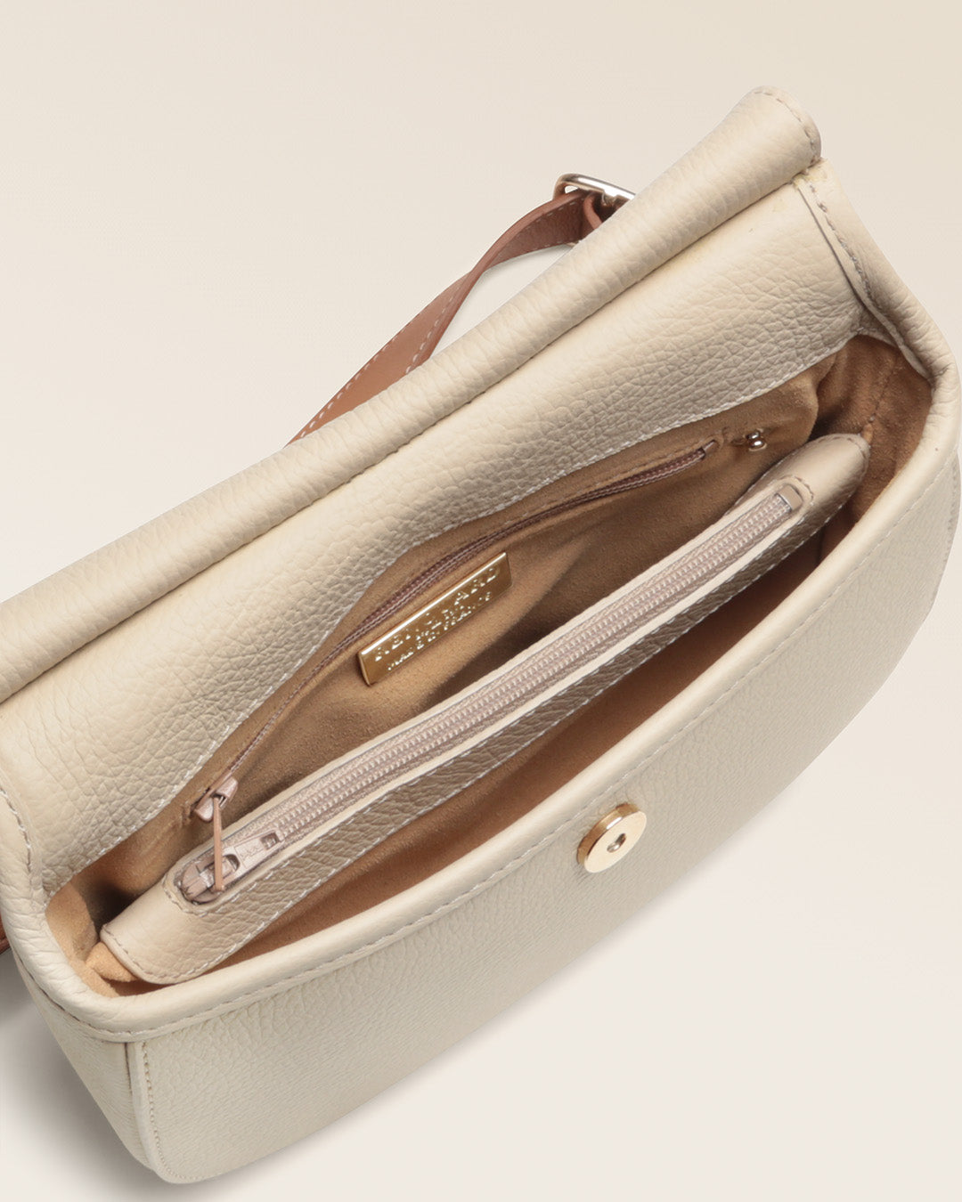 Notre sac Mini Cavalerie Renouard en cuir façon vigogne crème, vu de l'intérieur en studio.
