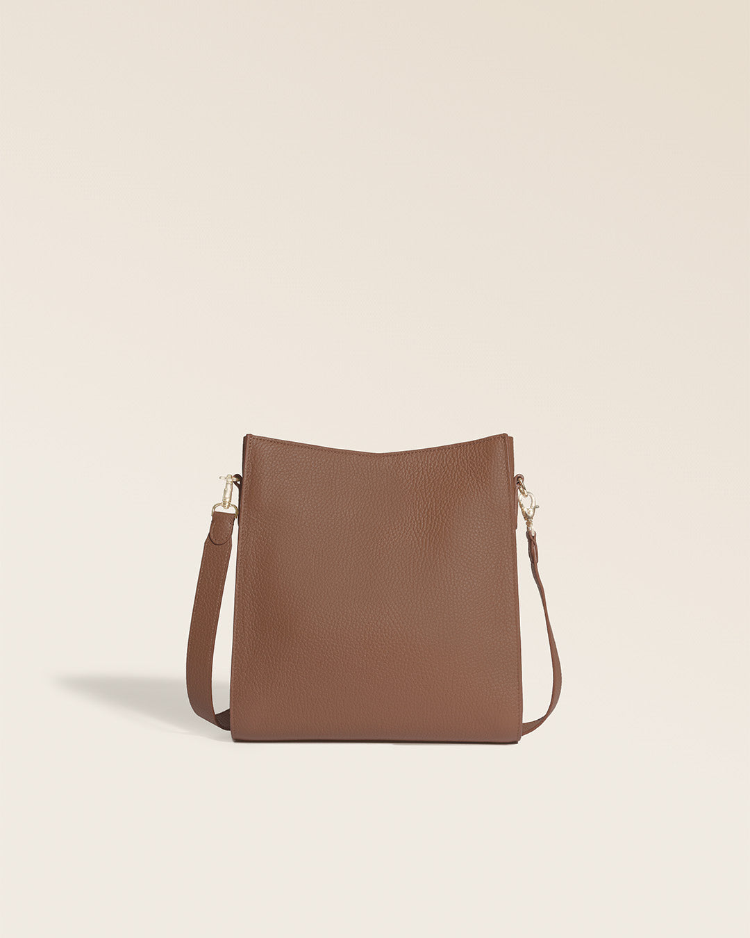Le sac Mini Étrivière Renouard en cuir façon vigogne fauve et sa bandoulière cuir, vu de dos en studio.