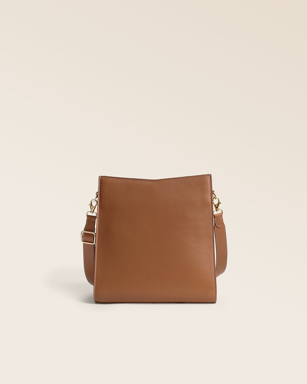Le sac Mini Étrivière Renouard en cuir lisse camel et bandoulière cuir, vu de dos en studio.