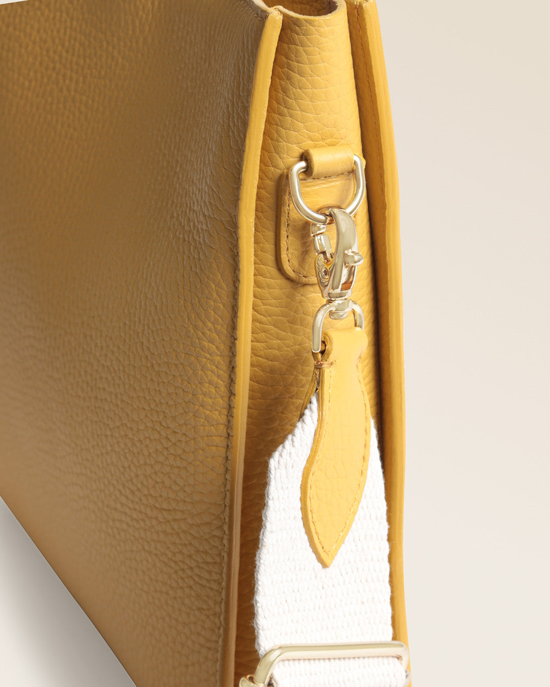 Le sac mini Étrivière Renouard en cuir vigogne ananas et sa bandoulière en craie, vu de près en studio.