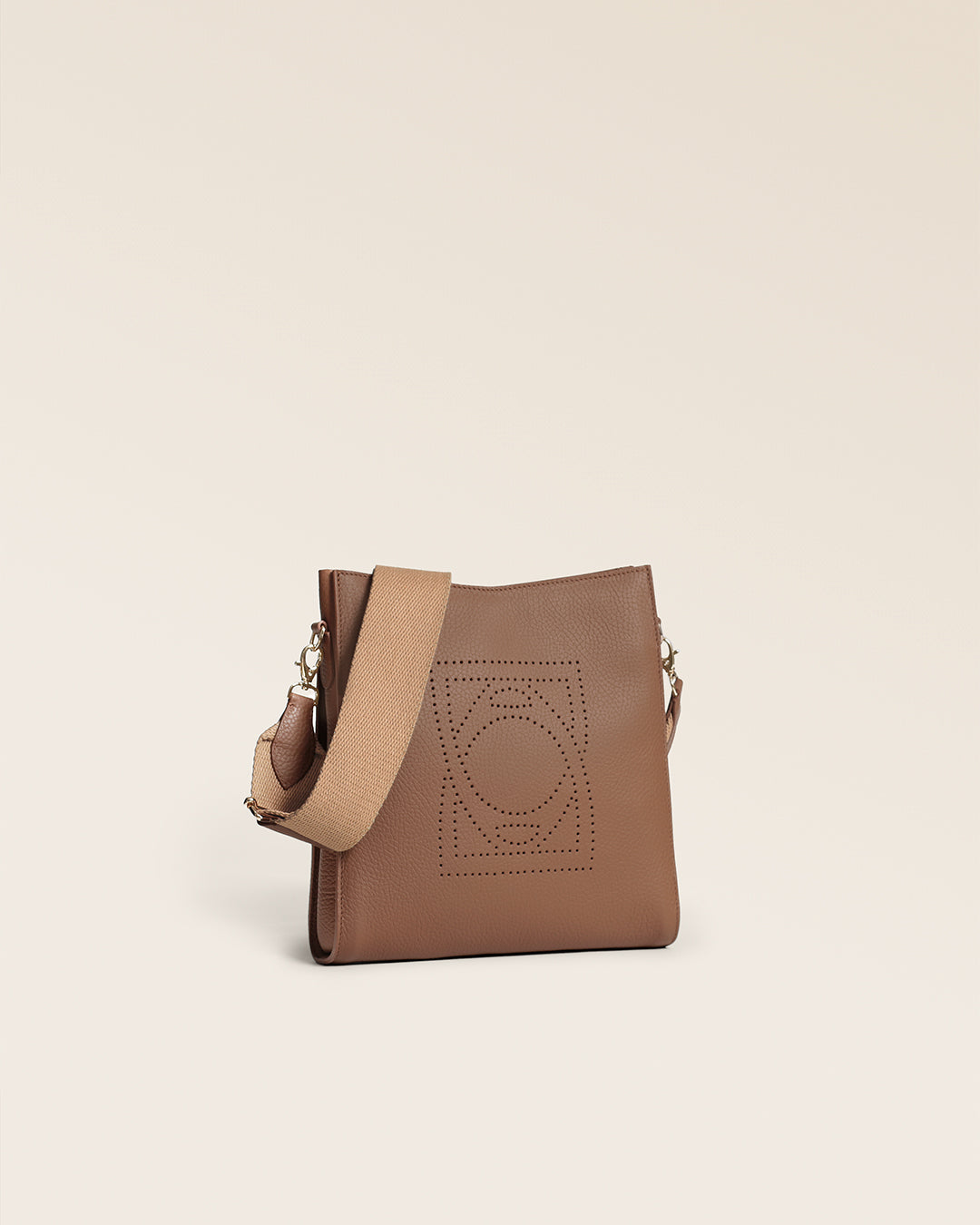 Le sac Mini Étrivière Renouard en cuir façon vigogne fauve et sa bandoulière coton camel, vu de quart en studio.