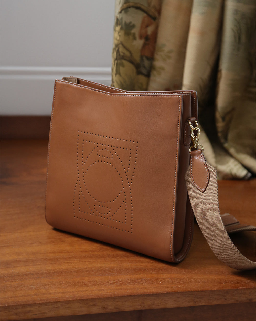 Notre sac Mini Étrivière Renouard en cuir vintage camel et bandoulière coton camel, vu en ambiance. 
