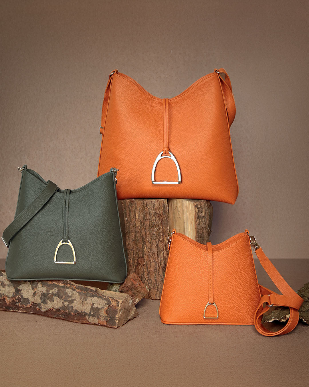 La Cob Family Renouard : l'iconique sac Cob en cuir façon vigogne orange, le sac Petit Cob en cuir façon vigogne kaki et le Mini Cob en cuir façon vigogne orange.