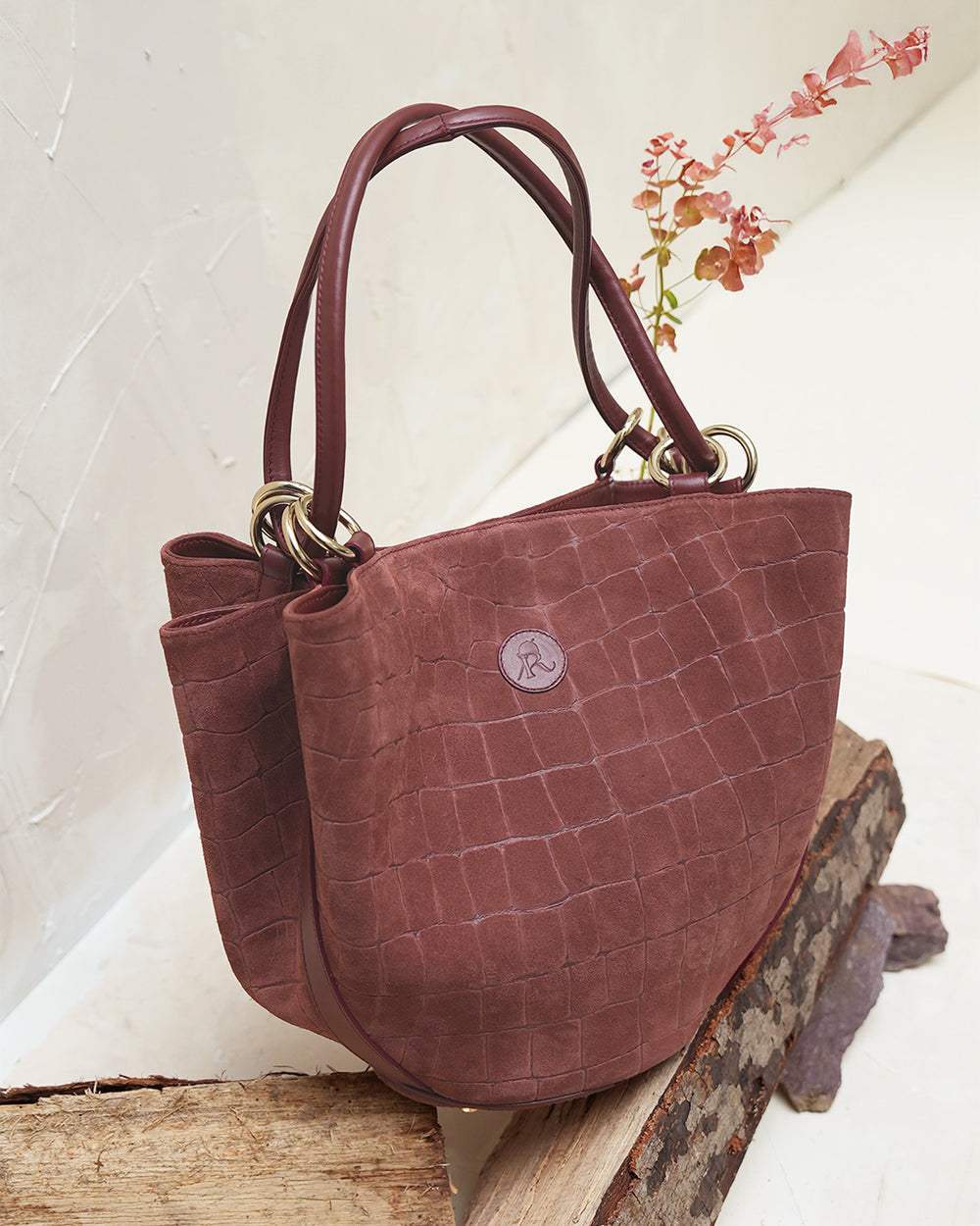 Le sac Païta Renouard en cuir veau velours façon croco acajou, vu de quart en ambiance.