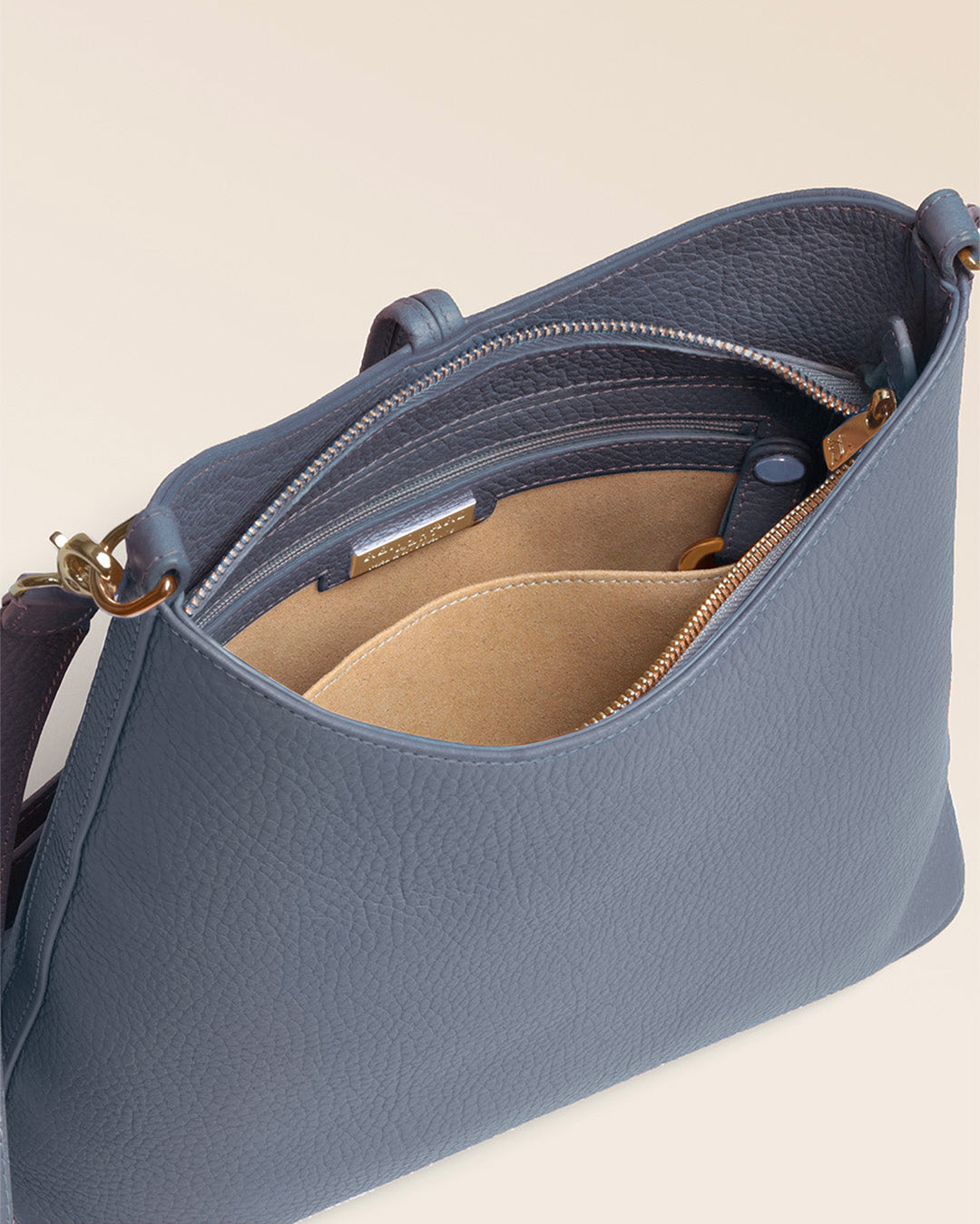 Notre sac Petit Cob Renouard en cuir façon vigogne bleu cobalt et bandoulière cuir, vu de l'intérieur en studio.