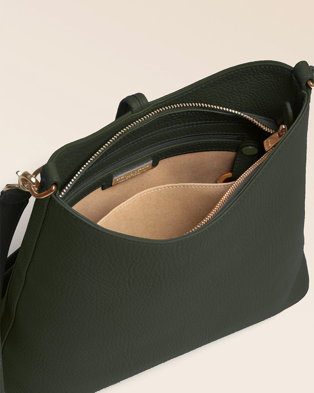 Notre sac Petit Cob Renouard en cuir façon vigogne kaki et bandoulière cuir, vu de l'intérieur en studio.