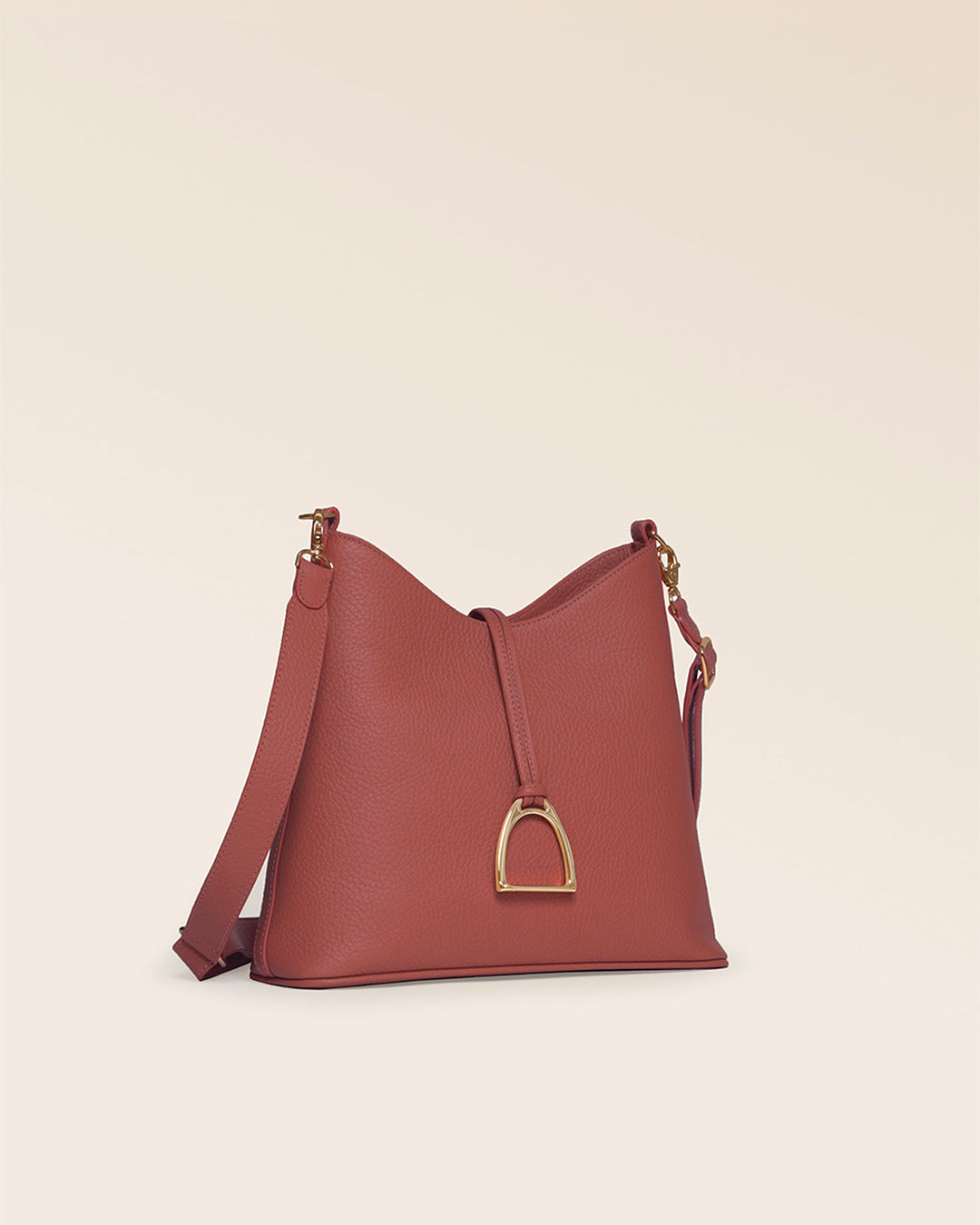 Notre sac Petit Cob Renouard en cuir façon vigogne terracotta et bandoulière cuir, vu de quart en studio.