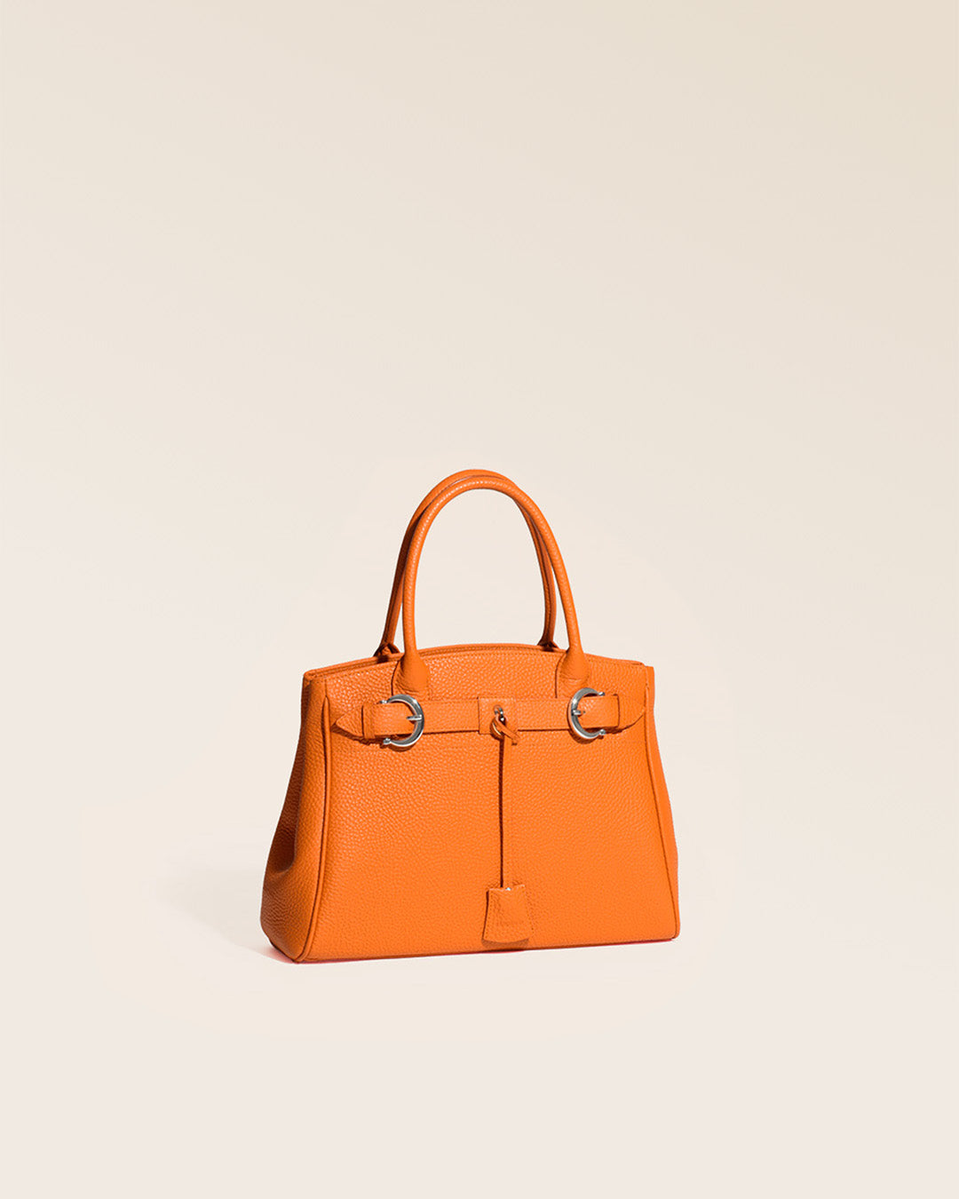 Our Prestige Renouard bag, in its Mini version, in orange vicuña-style leather, seen from the quarter in the studio.