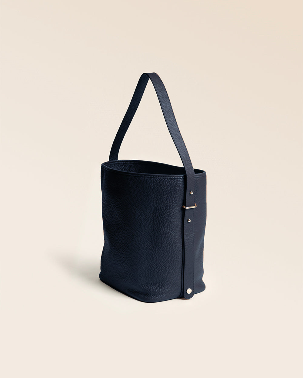 Notre sac Rio Renouard en cuir façon vigogne bleu marine, vu de quart en studio.