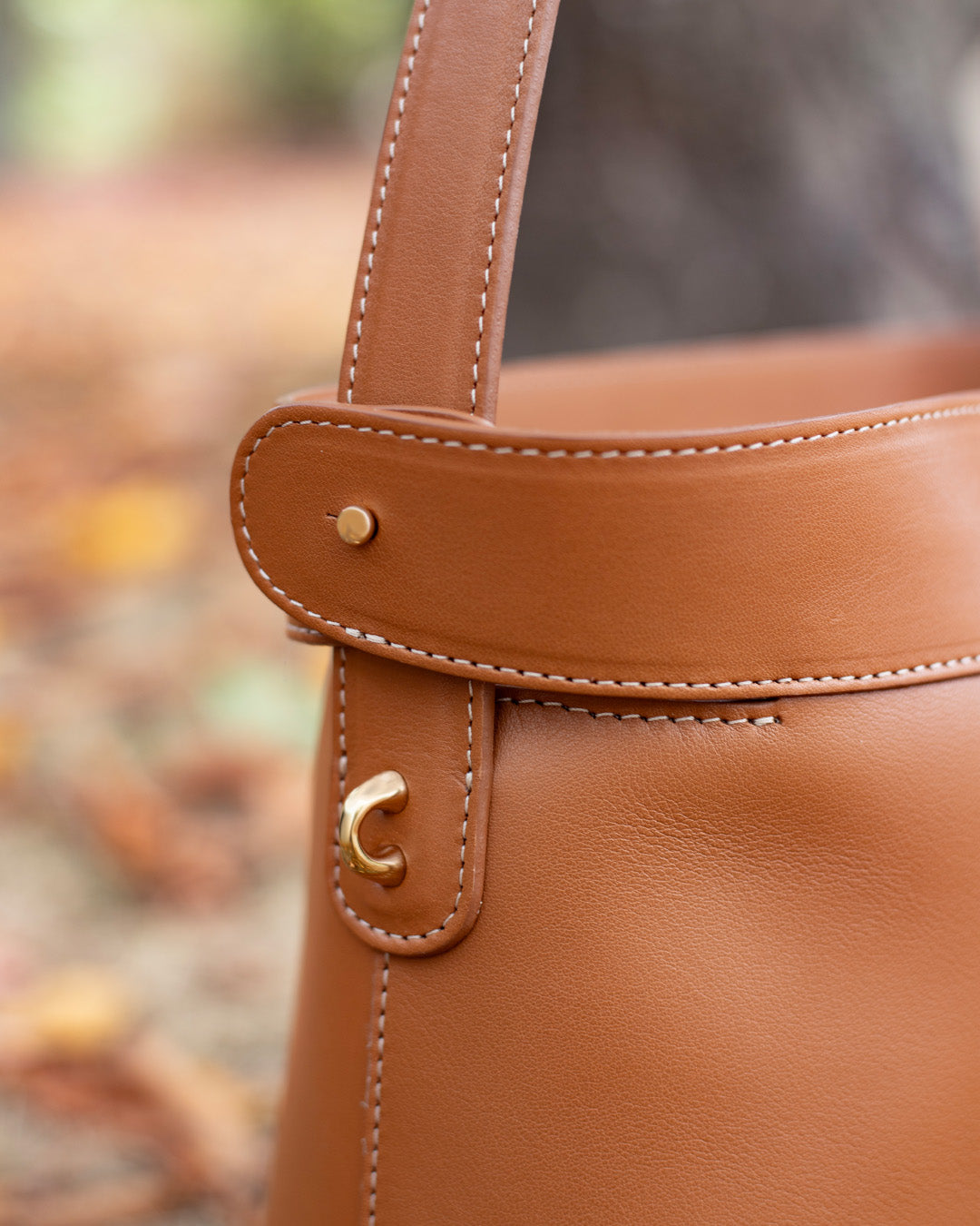 Le sac Rosa Grand modèle Renouard en cuir lisse camel, vu en détails en ambiance.