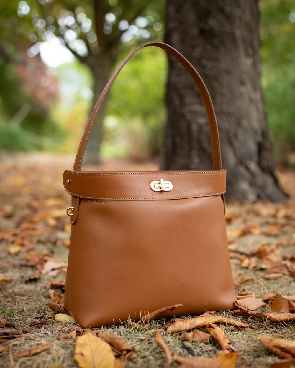 Le sac Rosa Grand modèle Renouard en cuir lisse camel, vu de face en ambiance.