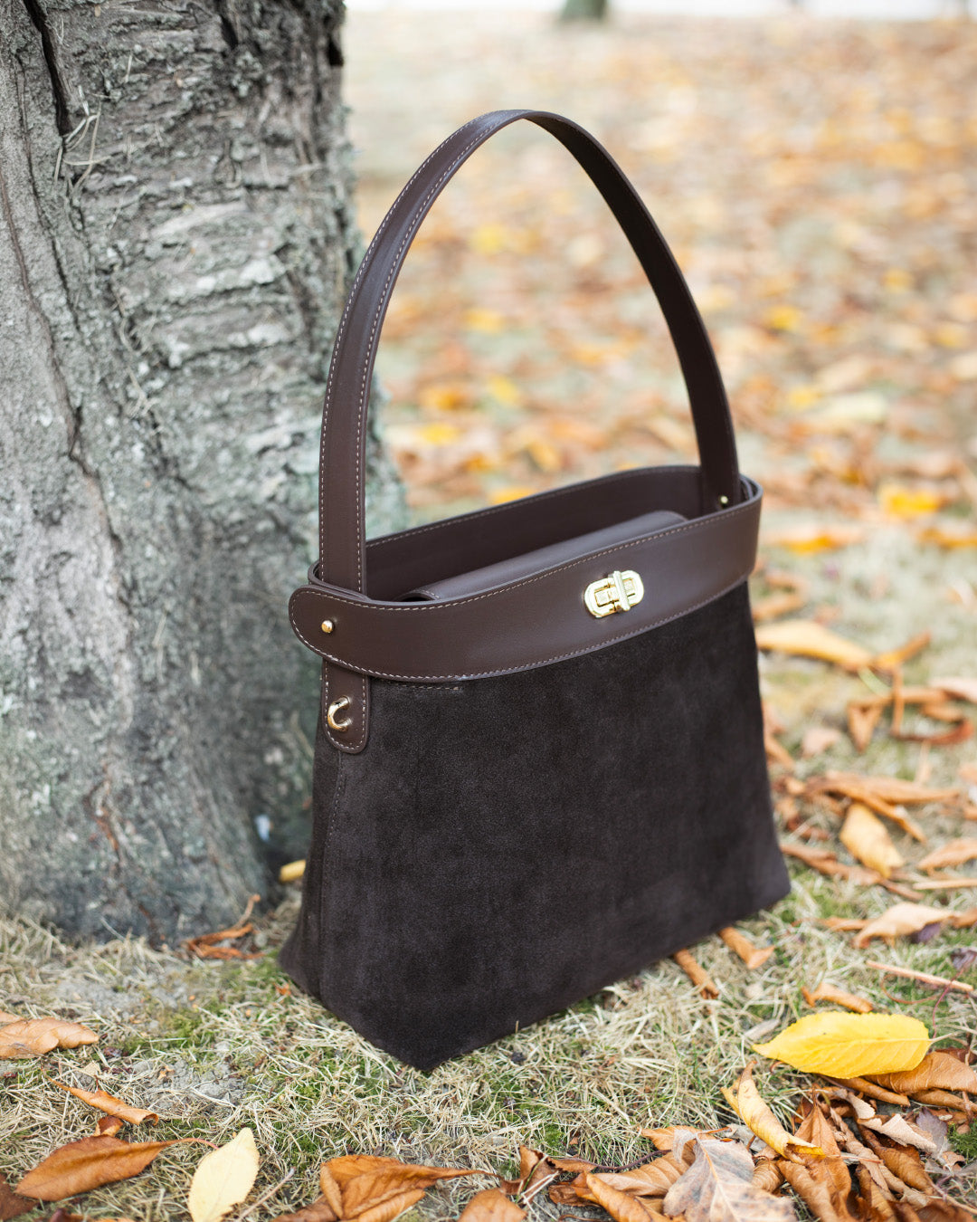 Le sac Rosa grand modèle Renouard en cuir veau velours espresso et cuir lisse ébène, vu de quart en ambiance.