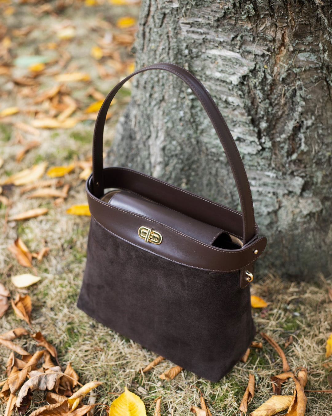 Le sac Rosa grand modèle Renouard en cuir veau velours espresso et cuir lisse ébène, vu de quart en ambiance.