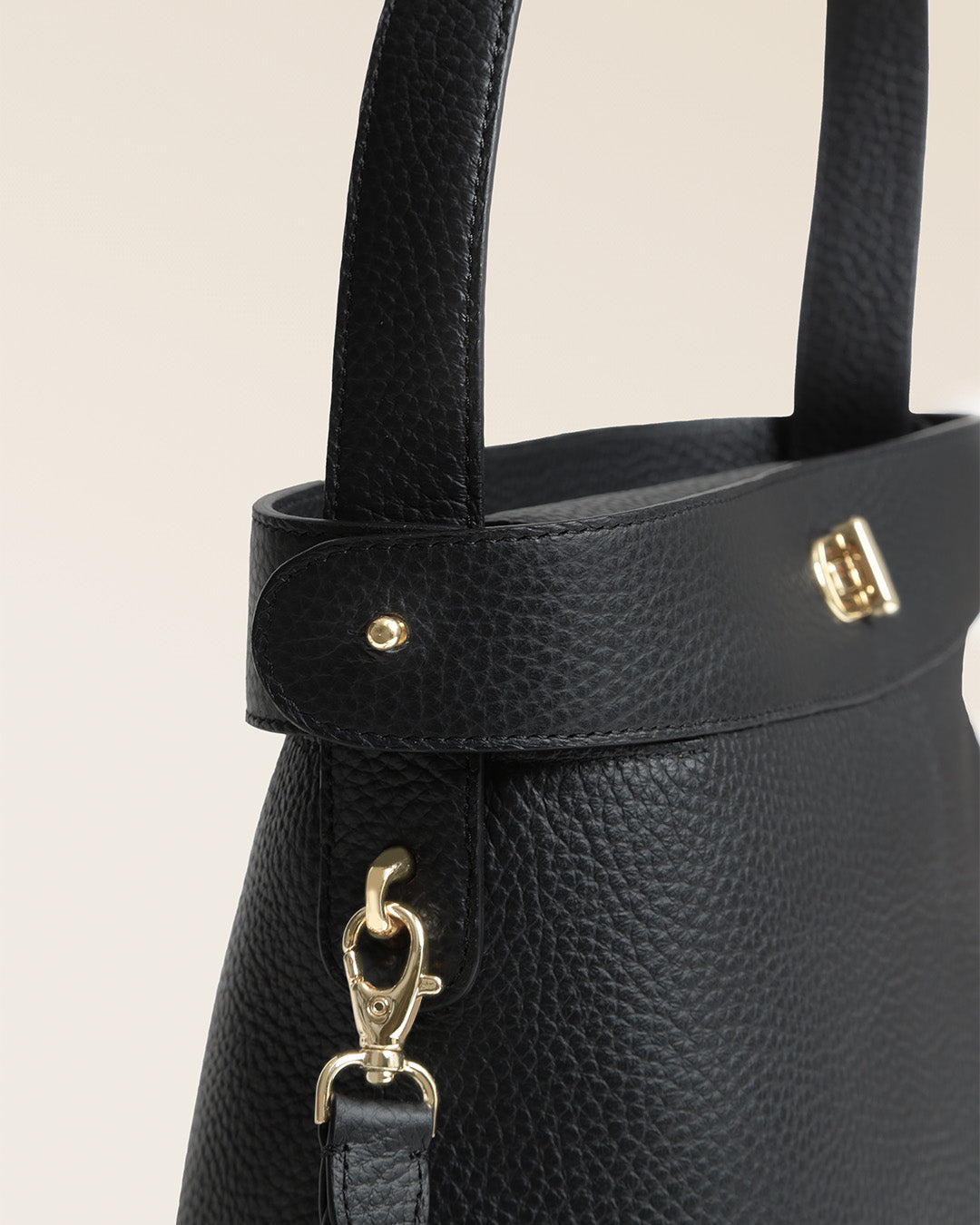 Le sac Rosa Renouard grand modèle en cuir façon vigogne noir et fermoir bijou doré pâle, vu de près en studio.