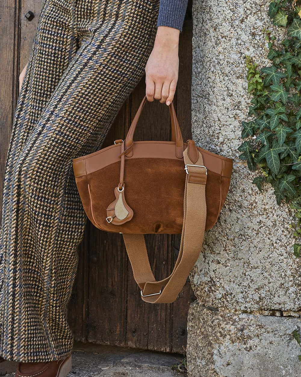 Notre sac Sarah Renouard en cuir veau velours noisette et cuir vintage camel, avec sa bandoulière coton, vu porté par notre mannequin. 
