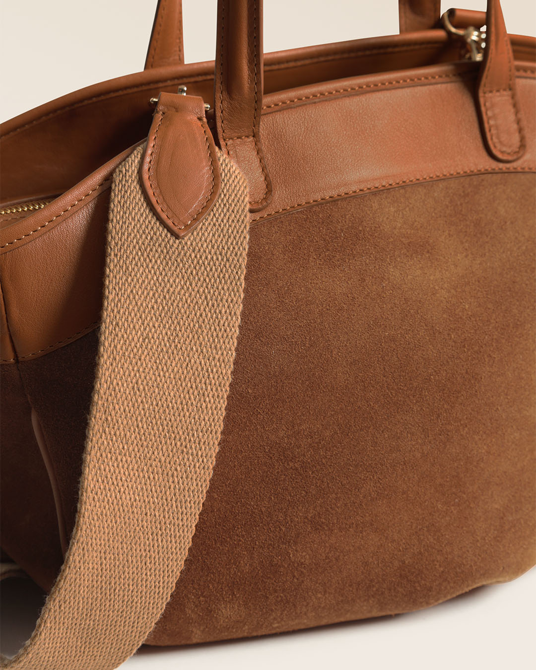 Notre sac Sarah Renouard en cuir veau velours noisette et cuir vintage camel, avec sa bandoulière coton, vu de près en studio.