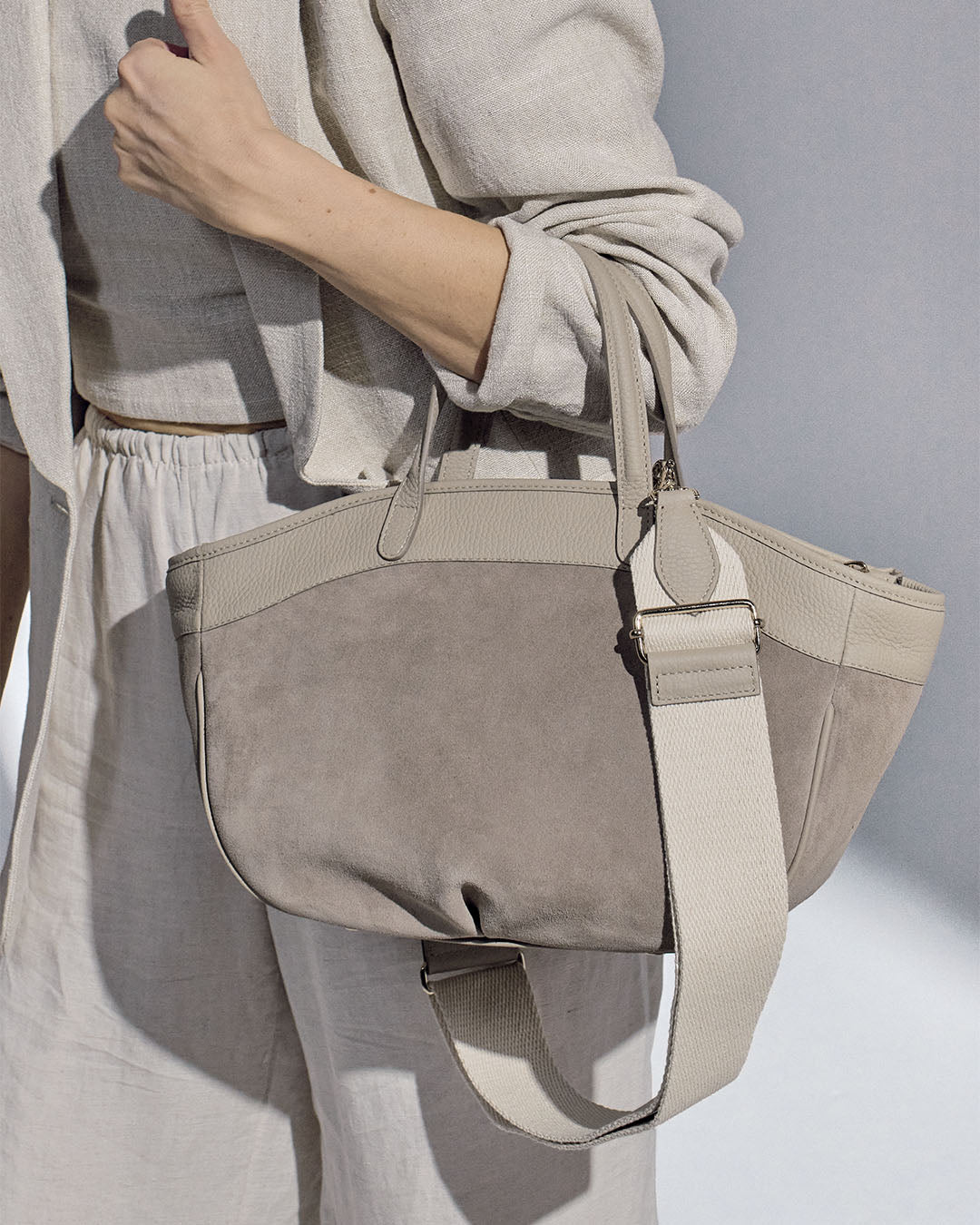 Notre sac Sarah Renouard en cuir veau velours taupe et cuir façon vigogne corde, vu porté par notre mannequin.