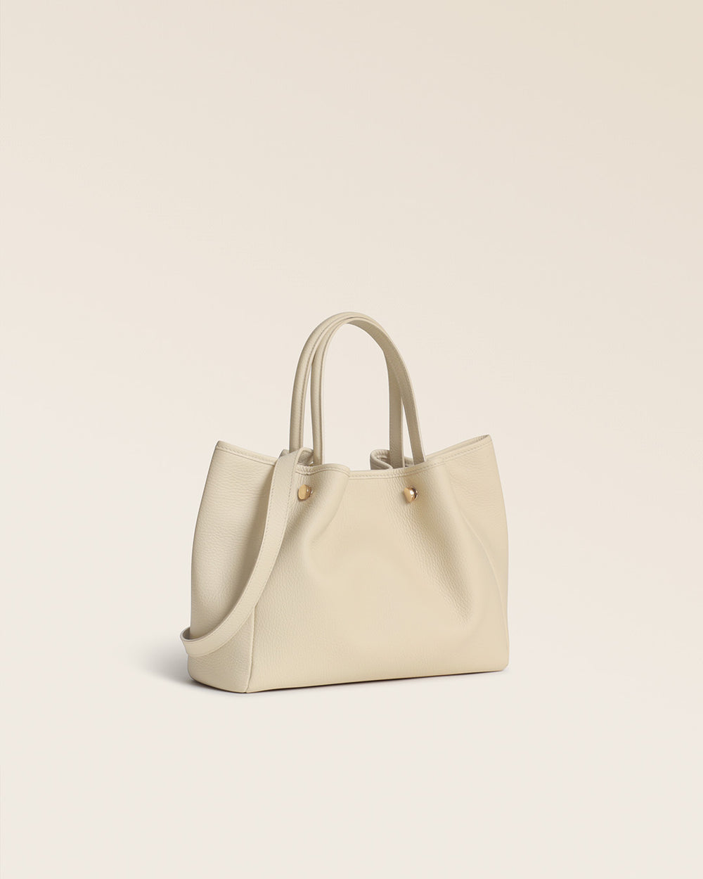 Notre sac Saturne Renouard en cuir façon vigogne crème, vu de quart en studio.