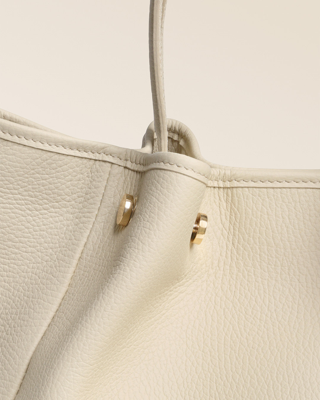 Notre sac Saturne Renouard en cuir façon vigogne crème, vu de près en studio.