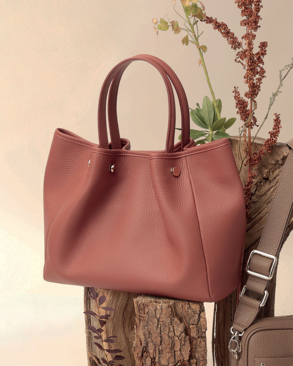 Le sac Saturne Renouard en cuir façon vigogne terracotta, vu de quart en ambiance. 