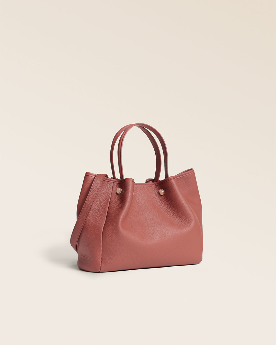 Le sac Saturne Renouard en cuir façon vigogne terracotta, vu de quart en studio.