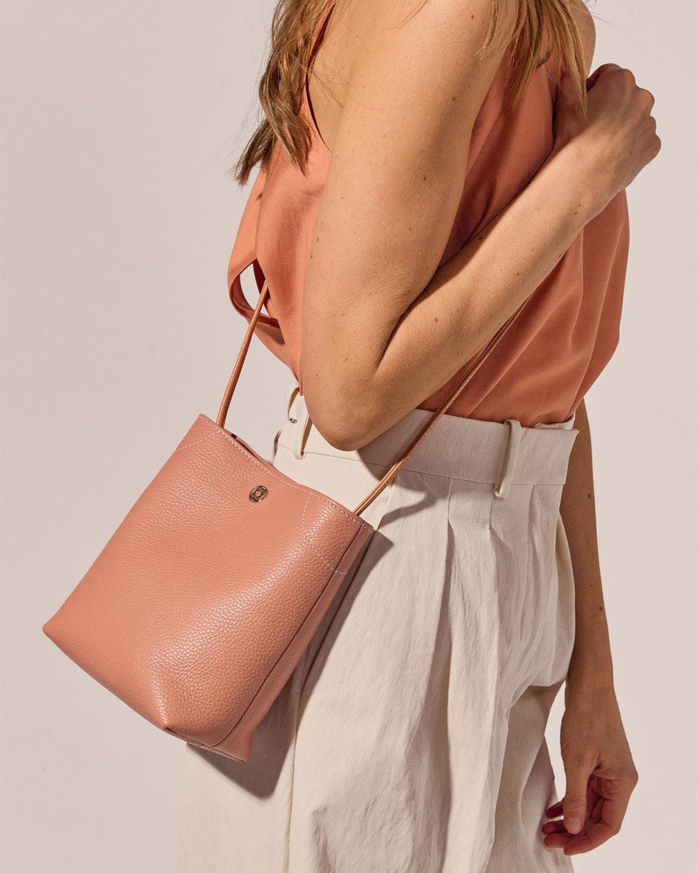 Notre sac Séquoia Renouard en cuir façon vigogne pêche, vu porté par notre mannequin. 