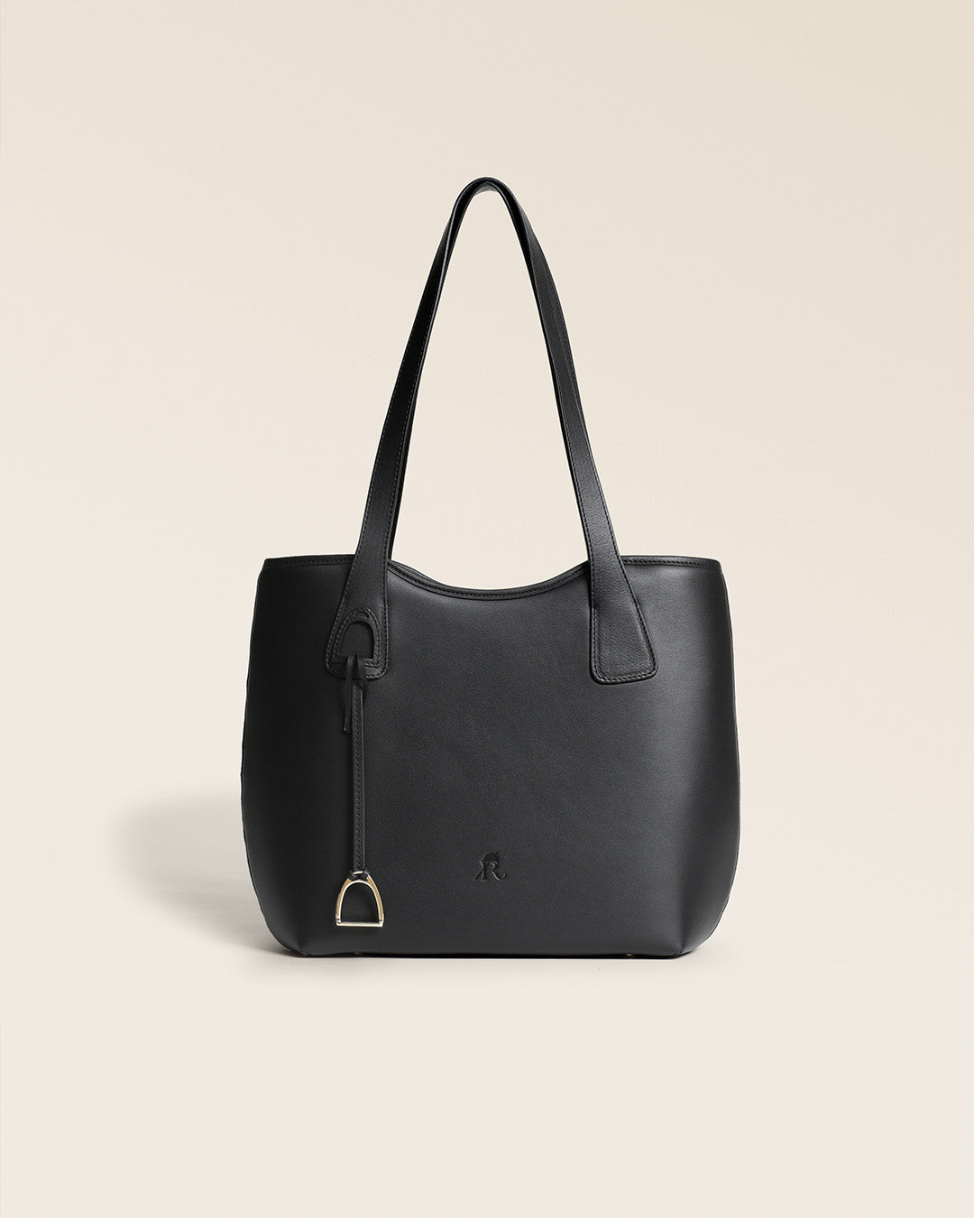 Le sac Soline Renouard en cuir lisse noir et son bijou étrier doré pâle, vu de face en studio.