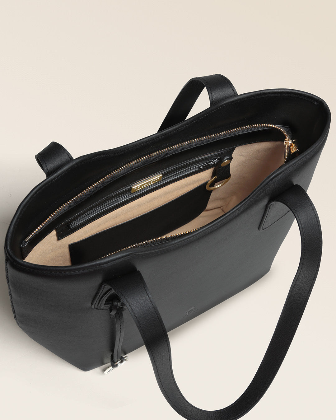 Le sac Soline Renouard en cuir lisse noir et son bijou étrier doré pâle, vu ouvert en studio.