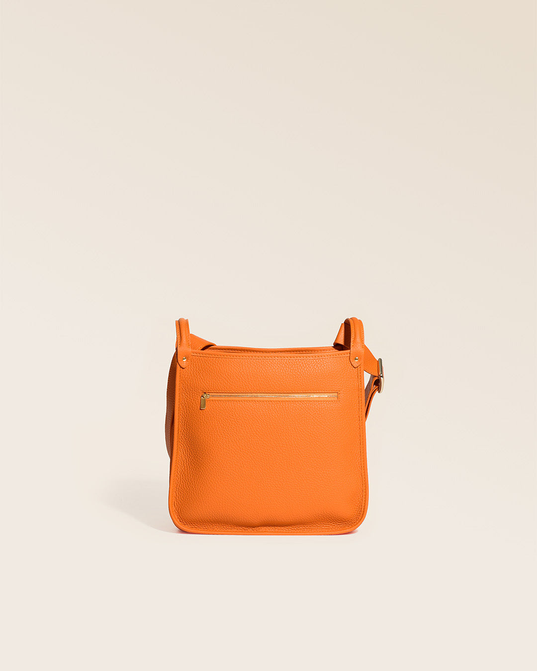Our orange vicuña-style leather Stan bag seen from the back in the studio.