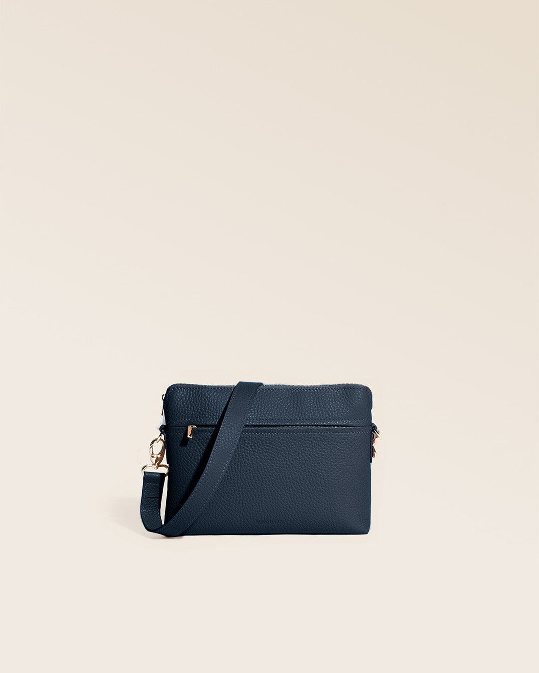 Notre sac Touline en cuir façon vigogne bleu marine vu de face en studio.