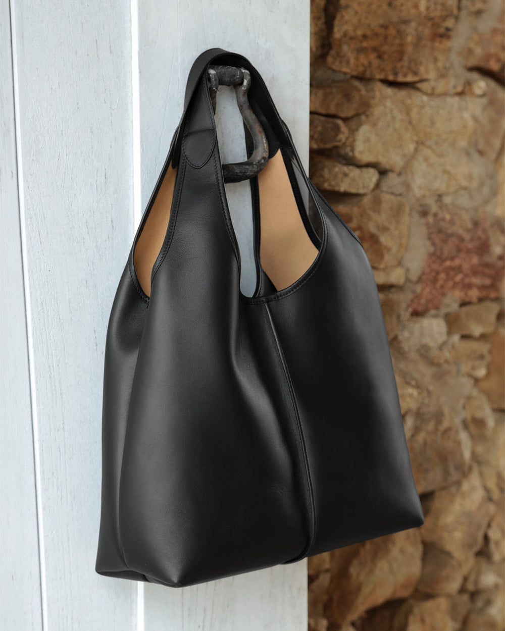 Notre sac Valentine Renouard en cuir lisse noir, vu de quart en ambiance.