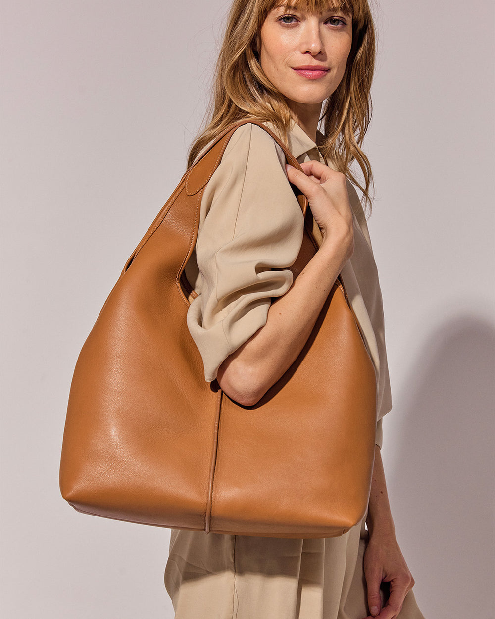 Notre sac Valentine Renouard, en cuir vintage camel, vu porté par notre mannequin. 