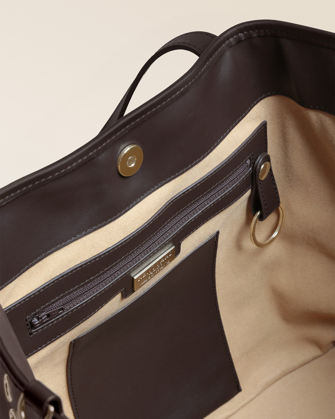 Le sac Zanzibar Renouard en cuir lisse ébène et ses oeillets dorés, vu ouvert en studio.