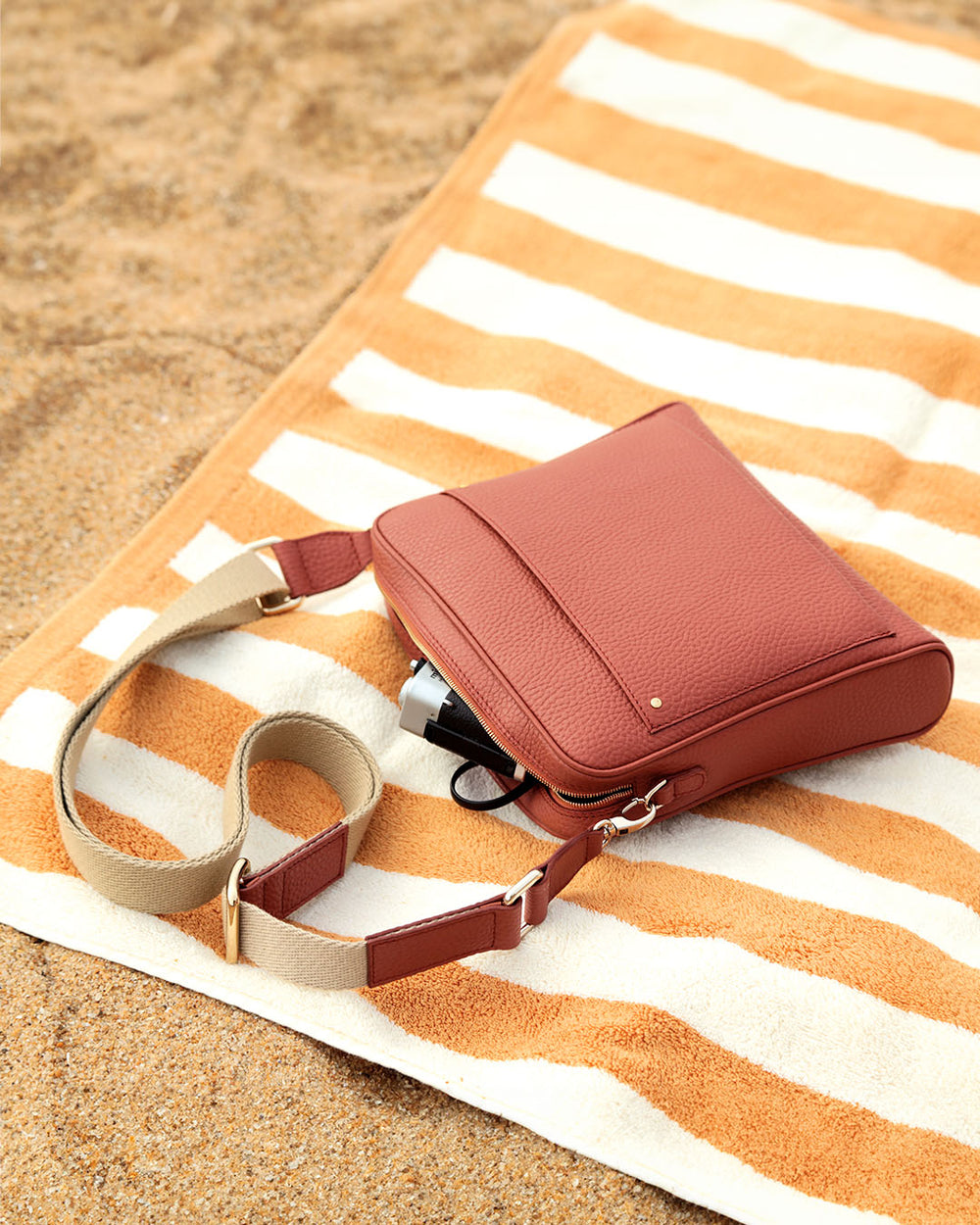 Notre sac Zoom en cuir façon vigogne terracotta et bandoulière sangle coton vu en ambiance.