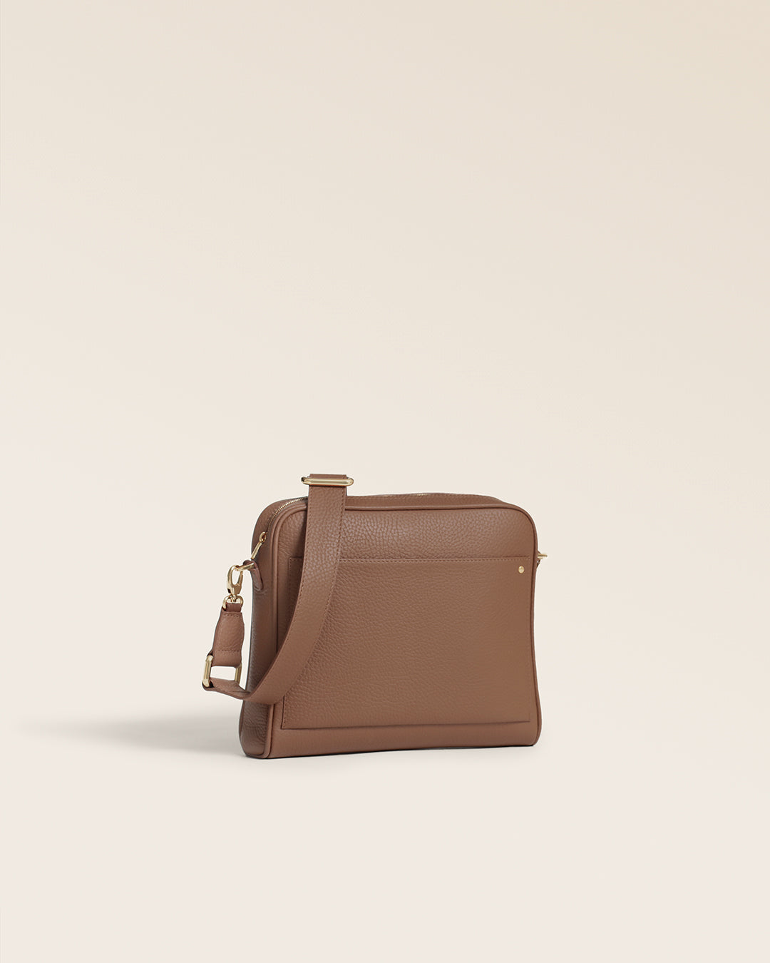 Le sac Zoom Renouard en cuir façon vigogne fauve et sa bandoulière cuir assortie, vu de quart en studio.