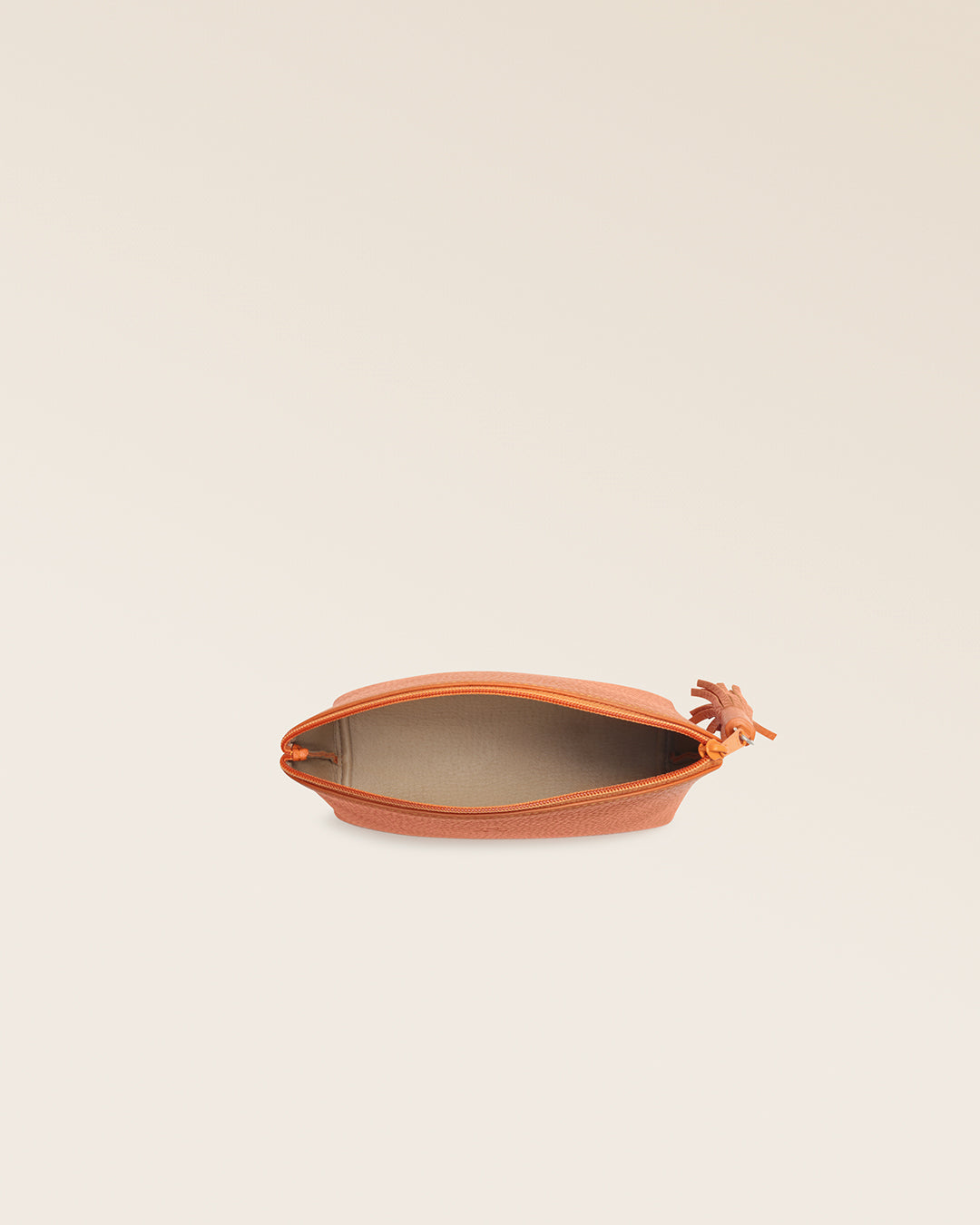 Notre trousse Astrid Renouard en cuir façon vigogne orange, vue du dessus en studio.