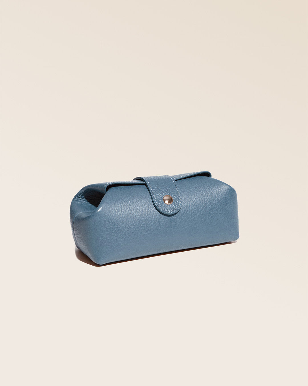Notre trousse Vecchio Renouard en cuir façon vigogne bleu cobalt vue de quart en studio.