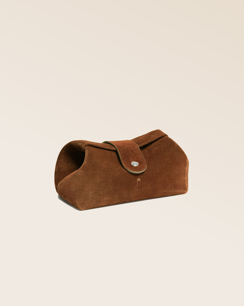 Notre trousse de voyage Renouard en cuir veau velours noisette vue de quart en studio.