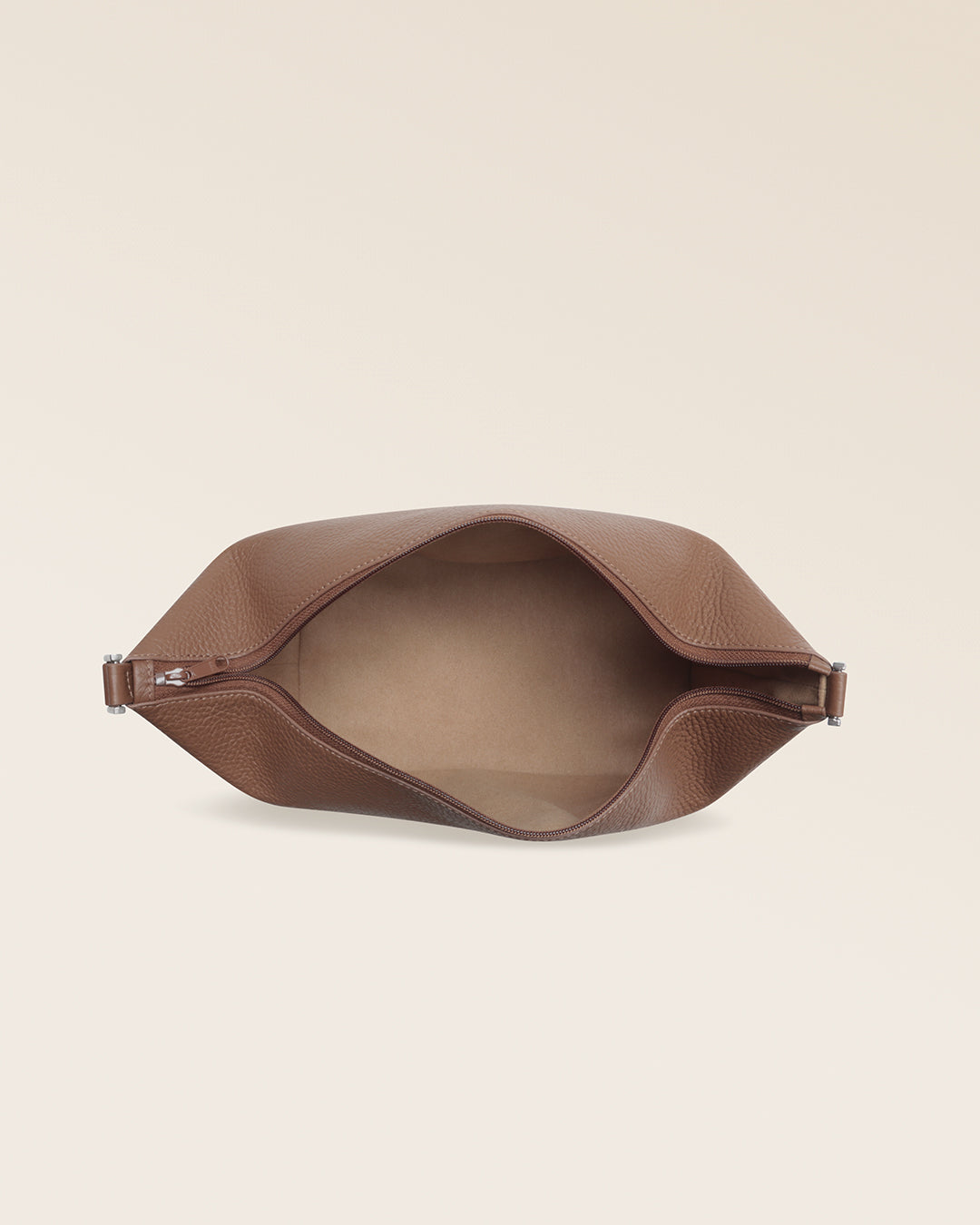 Notre trousse de voyage Renouard en cuir façon vigogne fauve, vue de l'intérieur en studio.