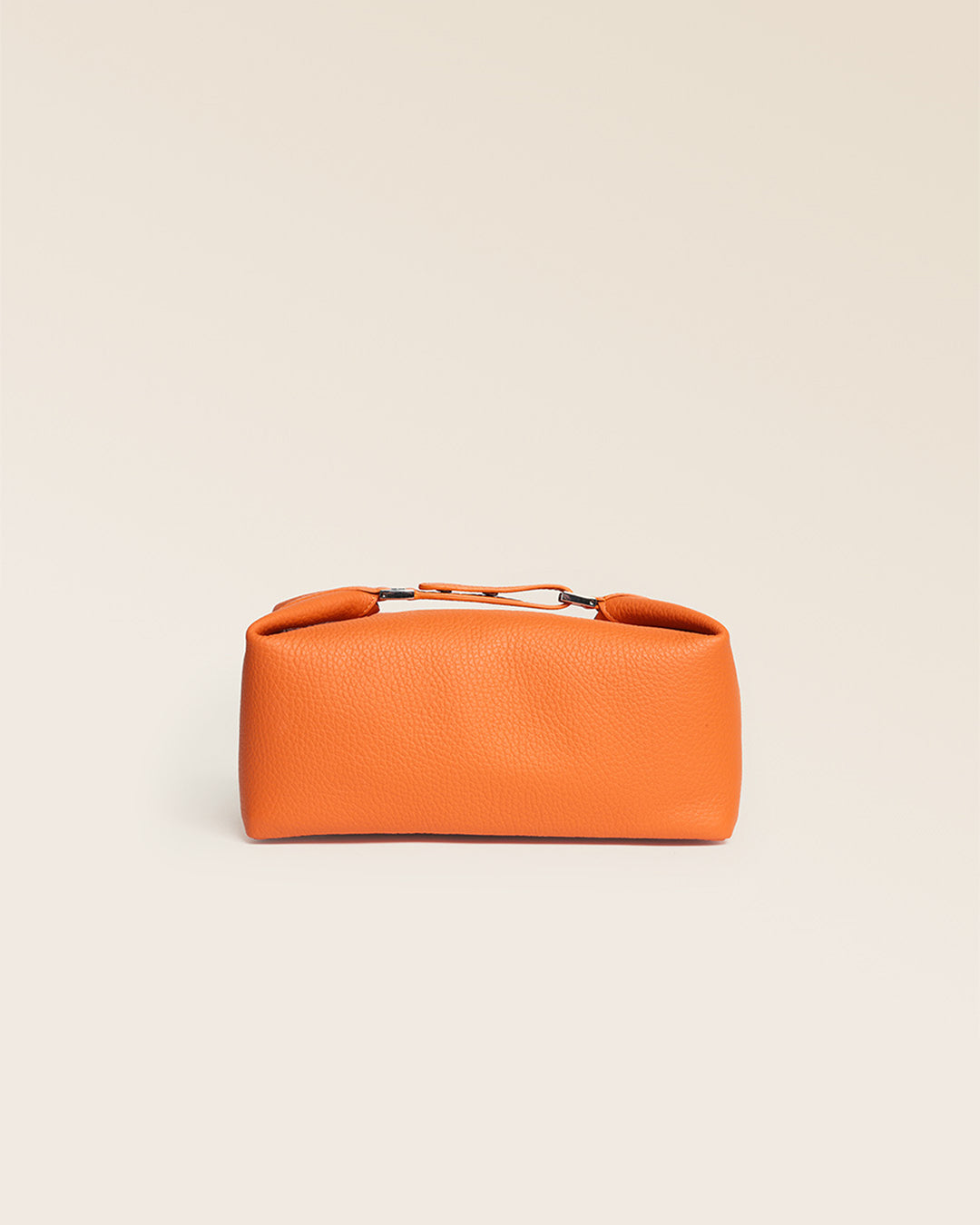 Notre trousse de voyage Renouard en cuir façon vigogne orange vue de face en studio.