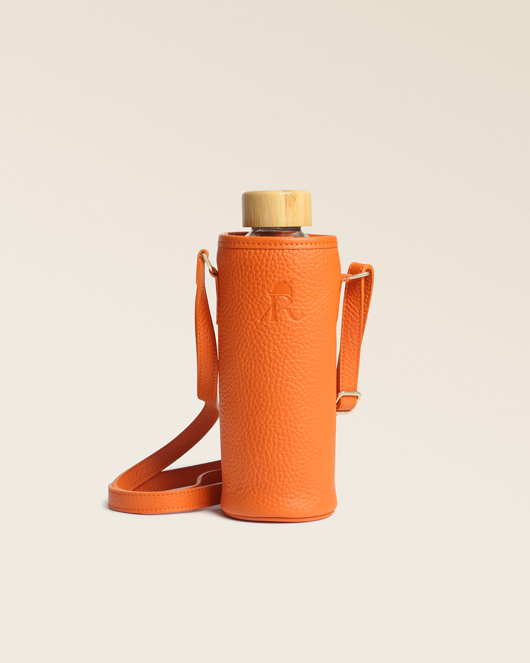 Notre étui pour bouteille d'eau ou gourde en cuir façon vigogne orange, vu de face en studio