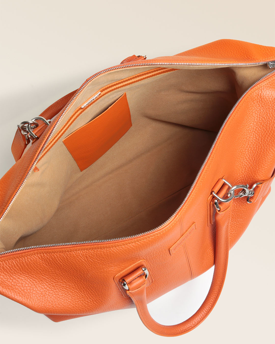 Notre sac Escapade Renouard dans sa version petit modèle, en cuir façon vigogne orange, vu du dessus en studio.