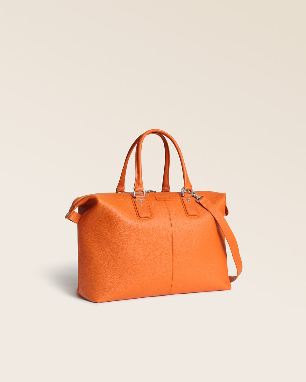 Notre sac Escapade Renouard dans sa version petit modèle, en cuir façon vigogne orange, vu de quart en studio.